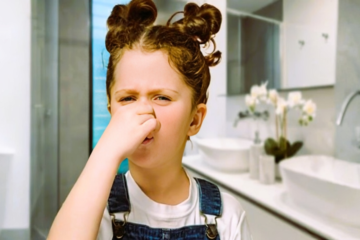 The image show a girl in bathroom when bathroom sink smell.