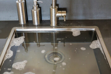 The image shows a clogged kitchen sink.