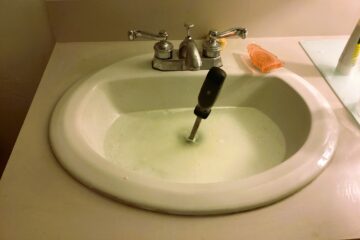 The image shows a bathroom sink that is not draining.